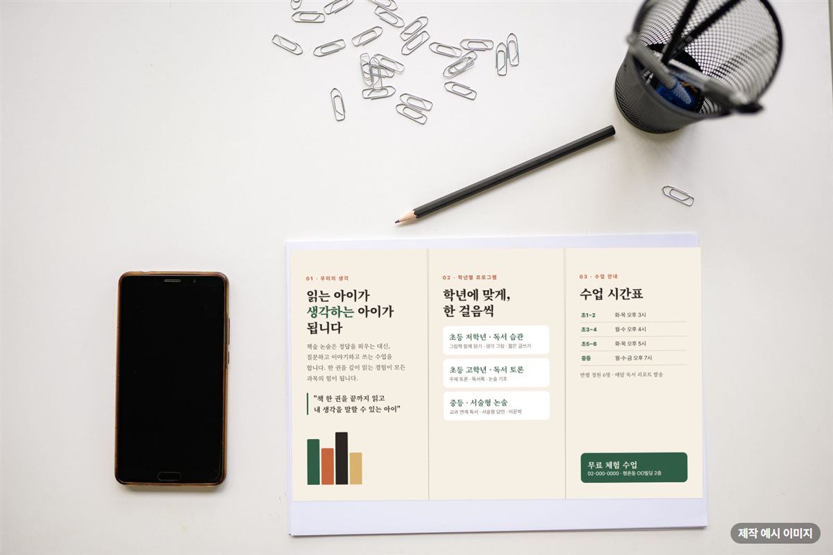 책상 위에 펼쳐 놓은 논술학원 3단 리플릿 제작 예시